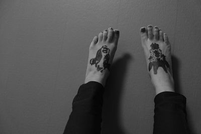 Low section of woman with tattoo on feet