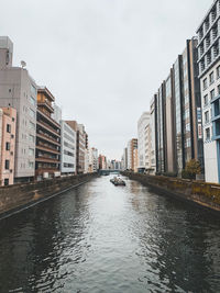 Canal amidst buildings against sky