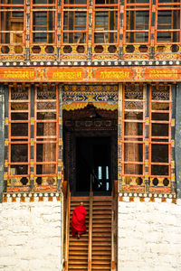 Rear view of monk climbing steps towards pagoda