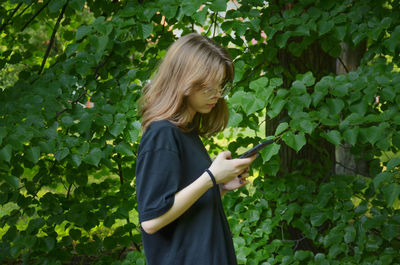 The girl is photographed near the greenery, portrait