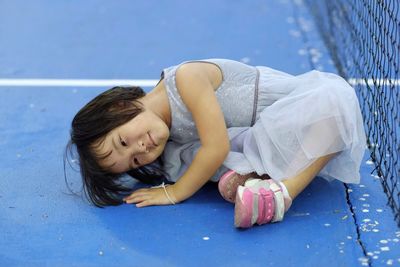 Happy girl playing with blue lying on the floor