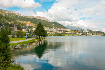 Scenic view of lake by buildings against sky