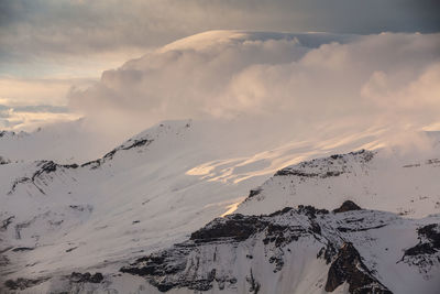 Aerial view of snow covered mountains against sky during sunset