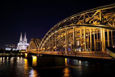 Illuminated bridge over river at night