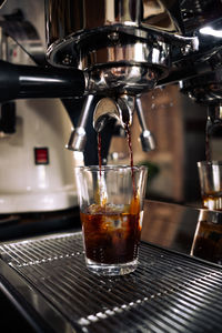 Fresh espresso shot pouring out of machine.