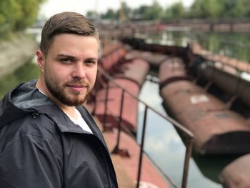 Side view portrait of man standing against canal