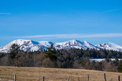 Scenic view of snowcapped mountains against blue sky