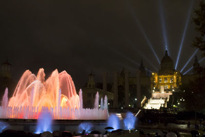 Illuminated fountain in city at night