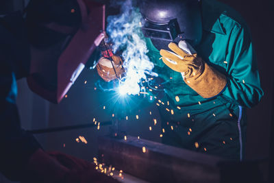 Worker welding in workshop