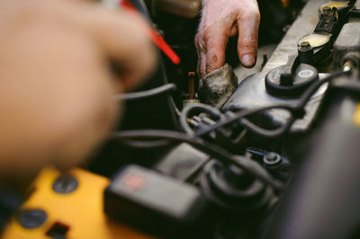 Cropped hands of mechanic repairing engine