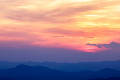 Scenic view of silhouette mountains against romantic sky at sunset