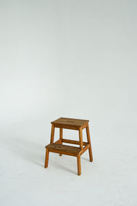 Empty chair on table against white background