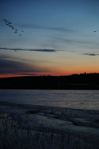 Scenic view of frozen lake against sky during sunset