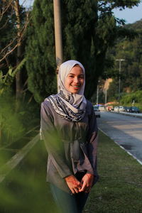 Portrait of happy woman standing at roadside