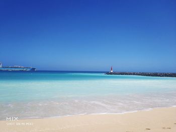 Scenic view of sea against clear blue sky