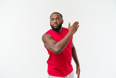 Portrait of young man standing against white background