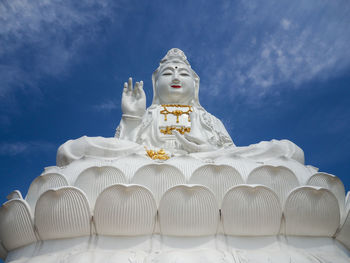 Low angle view of statue against temple against sky