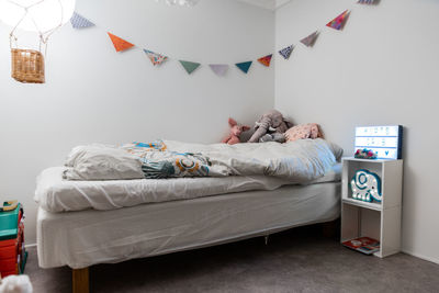 Boy sleeping on bed against wall at home