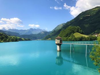 Scenic view of lake and mountains against blue sky