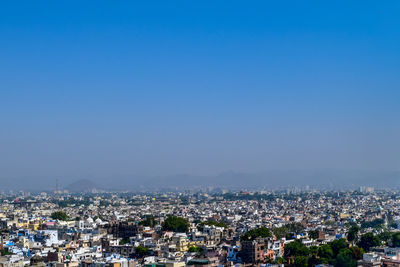 High angle shot of townscape against blue sky