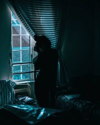 Rear view of woman sitting on floor