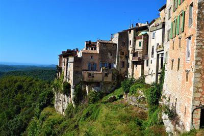 Low angle view of old buildings against clear blue sky