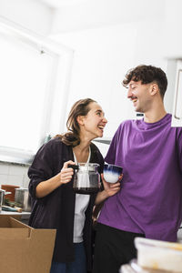 Smiling couple drinking coffee in kitchen