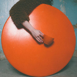 High angle view of woman with orange cup on orange table