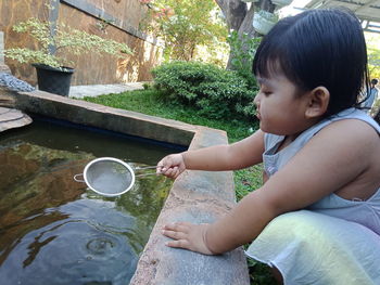 Boy sitting by water