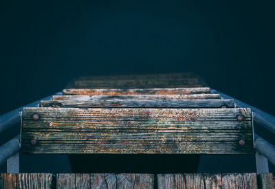 Close-up of wooden ladder on black background