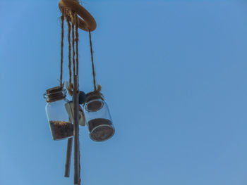 Low angle view of telephone pole against clear blue sky