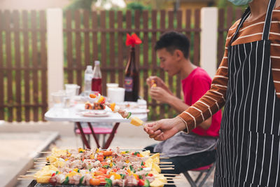 Midsection of woman holding food at market stall