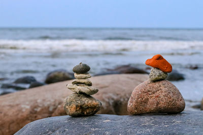 Stack of stones on beach against sky