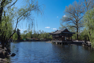 Gazebo in lake against blue sky