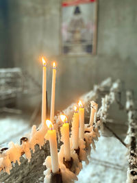 Close-up of lit candles in temple