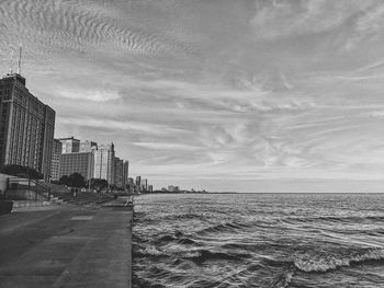 Scenic view of sea by buildings against sky