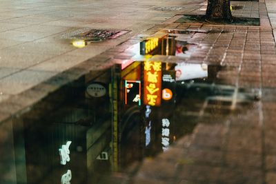 Reflection of illuminated building in puddle