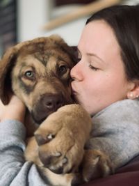 Close-up of teenage girl kissing dog