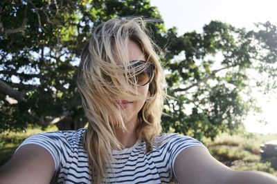 Close-up of young woman against trees