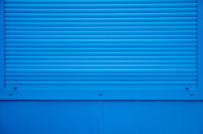 Full frame shot of shutter on blue wall