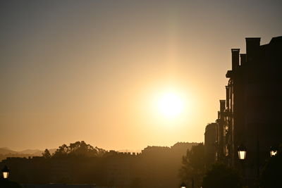 Silhouette buildings against sky during sunset