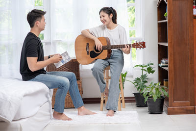 Young couple playing guitar at music concert