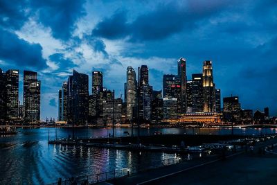 Illuminated cityscape against cloudy sky