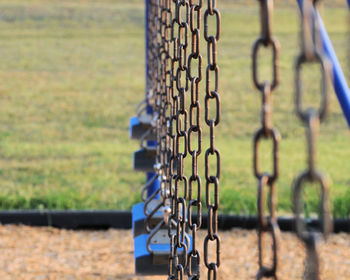 Close-up of padlock hanging on chainlink fence