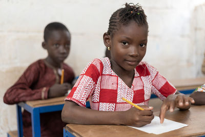 Portrait of a smiling girl holding table