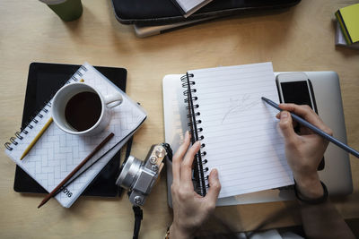 Directly above shot of woman drawing in book at office