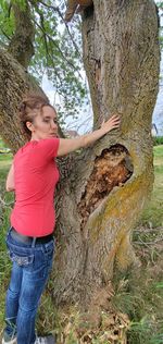 Full length of woman standing on tree trunk