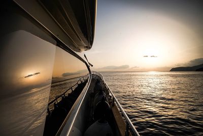 Cropped image of sailboat in calm sea at sunset