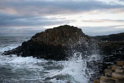 View of rock formation in sea against sky