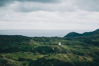 Scenic view of landscape by sea against sky